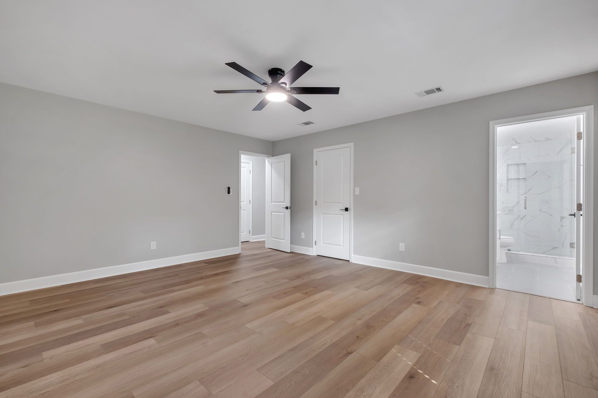 Primary bedroom, with the en-suite bathroom opening off the far wall
